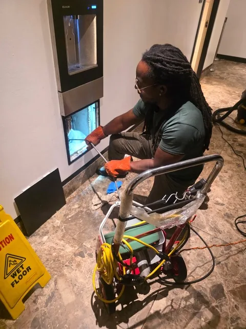 A&L technician Trent Paul feeding a Spartan 100 electric rodding line into a wall drain
