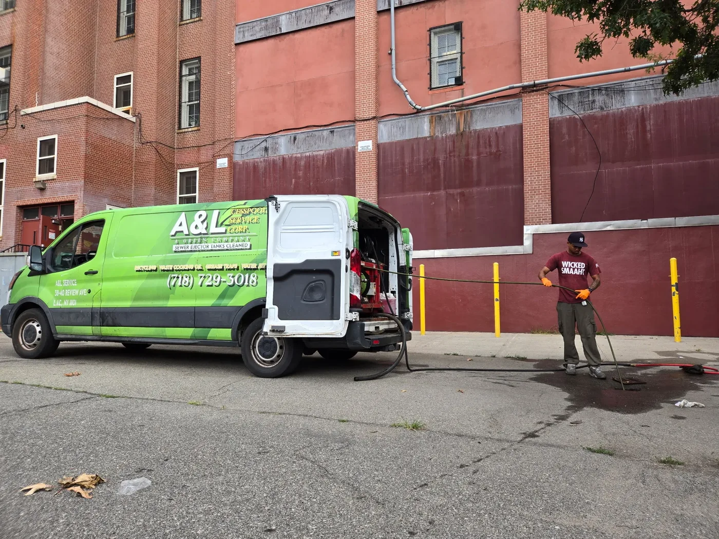 A&L technician working a sewer ejector line beside the green jetting van